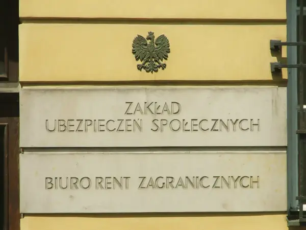 Tablica z napisem "Zakład Ubezpieczeń Społecznych" i godłem Polski.