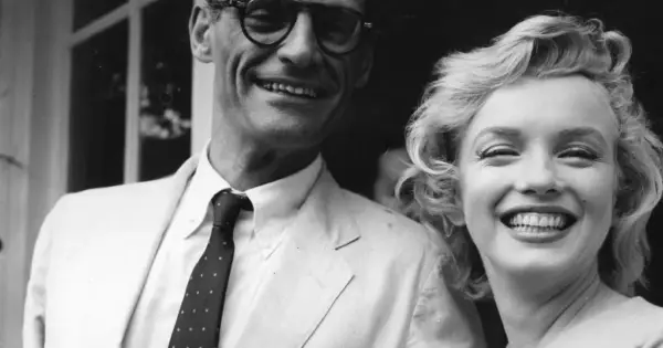 Marilyn Monroe i jej mąż Arthur Miller uśmiechają się radośnie do zdjęcia.
