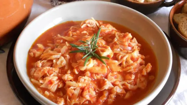 Trippa ricetta della nonna in un piatto bianco, guarnita con rosmarino. Un classico sapore di casa.