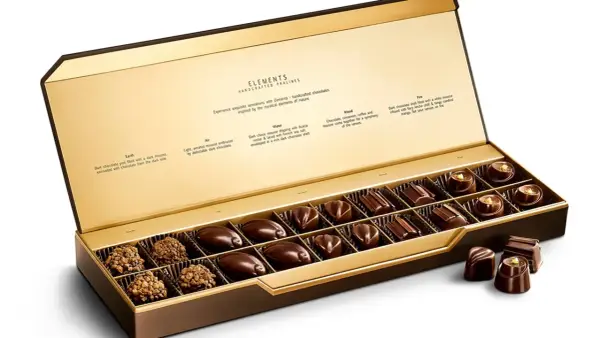 Caja abierta de chocolates finos, "la chuche más cara del mundo", con descripciones de sabores inspirados en elementos naturales.