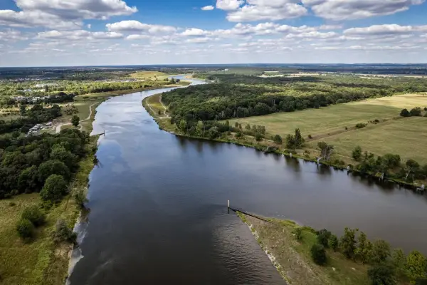 Malowniczy widok na rzekę i tereny zielone, idealne na spacer z psem. Psie pole Wrocław zaprasza!