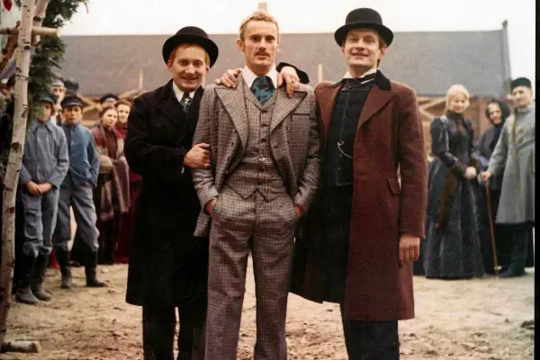 Trzech mężczyzn w melonikach i eleganckich strojach, jak z najlepsze filmy ranking. W tle tłum ludzi.