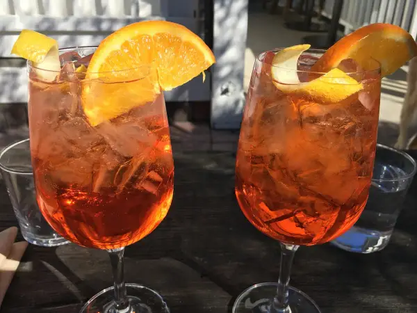 Dwa orzeźwiające drinki z pomarańczą i lodem. Idealne na aperitivo, co to jest? To włoska tradycja!