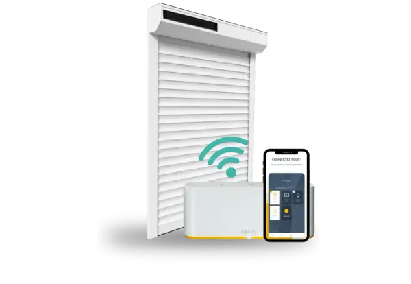 Installation domotique volet roulant : un volet blanc, une box Somfy et un smartphone affichant l'application de contrôle.