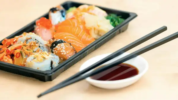 En låda med sushi och sashimi, redo att ätas. Perfekt för den som vill **springa efter mat** utan att kompromissa med smaken.