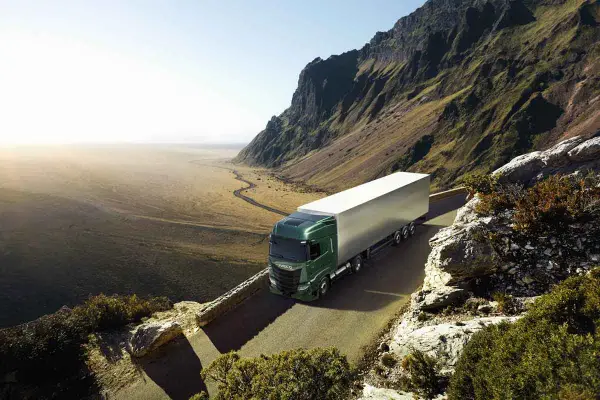 Camión Iveco S-Way 530 verde en carretera montañosa. Las opiniones sobre este modelo son muy positivas.
