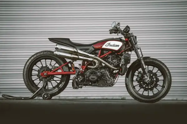Stylowy Indian FTR 1200 w kolorze czerwono-białym, z podwójnym wydechem i czarnymi felgami, gotowy do jazdy.