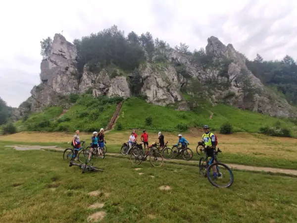 Grupa rowerzystów na tle skalnych ostańców. Jura Krakowsko-Częstochowska rowerem to wspaniała przygoda.