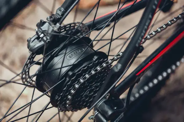 Widok z bliska na kasetę w rowerze elektrycznym Bafang, z widocznym hamulcem tarczowym i łańcuchem.