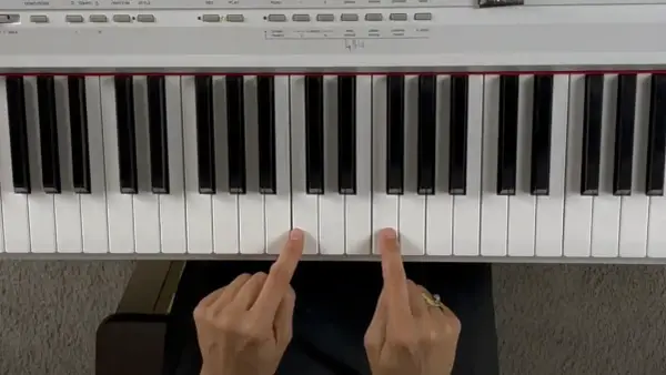 Deux doigts jouent un accord de piano.