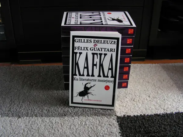 Stos książek z "Kafką" Deleuze'a i Guattariego, z widocznym żukiem na okładce, nawiązującym do prozy Franza Kafki.