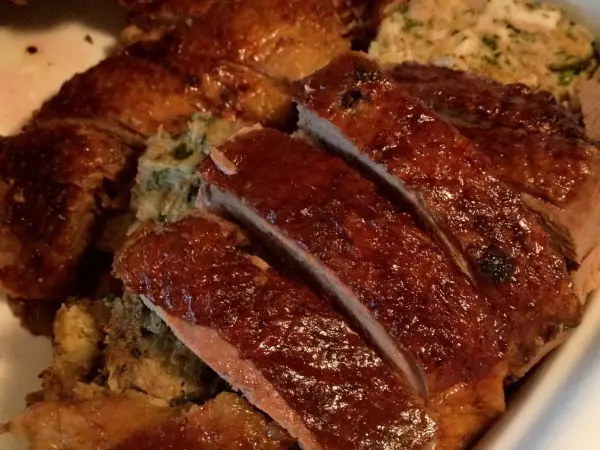 Gęś Ania gotuje. Pyszna, pieczona gęś z chrupiącą skórką i aromatycznym farszem, pokrojona na kawałki.