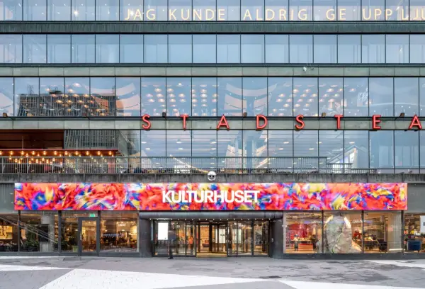 Stockholms kulturhus med en färgstark digital konstinstallation ovanför entrén.