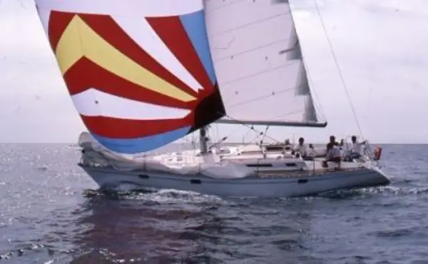 Un voilier avec une voile colorée, rappelant une légende du soleil, navigue sur une mer agitée. 41 avis sur cette aventure.