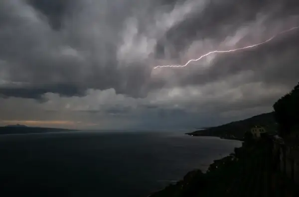Éclair zébrant le ciel sombre au-dessus du lac Léman, annonçant une violente tempête.