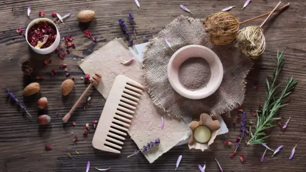 Zutaten für **shampoo selber machen**: Rosenblätter, Lavendel, Mandeln, Haselnüsse, Rosmarin, Honig, Tonerde und ein Holzkamm.