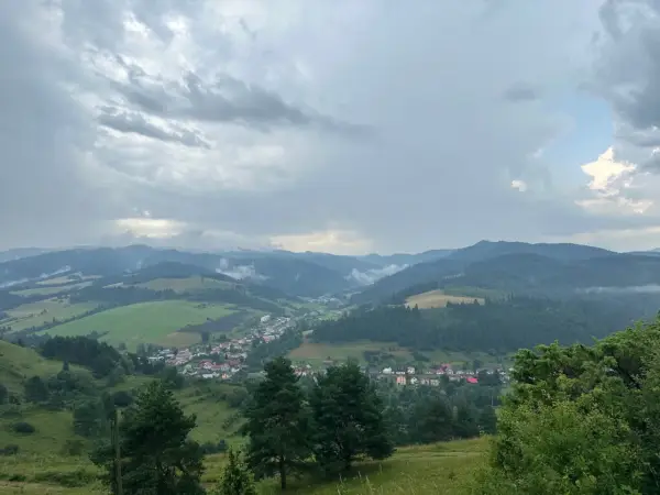 Widok na dolinę z wioską i górami w tle, chmury nad przełęczą pod Tokarnią.