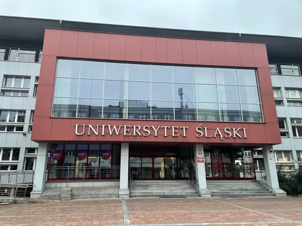 Uniwersytet Śląski w Katowicach, nowoczesny budynek z dużymi oknami i napisem uczelni. Idealne miejsce na studia.