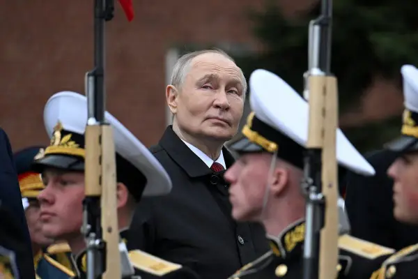 Władimir Putin w otoczeniu żołnierzy w mundurach, gdzieś w tle widać ceglany mur. To obraz, który przypomina o dawne słowo honoru.