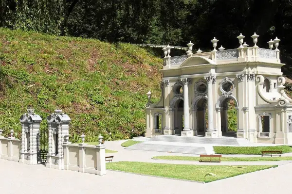 Miniaturowa budowla z kolumnami i bramą, jak w parku miniatur województwa mazowieckiego.
