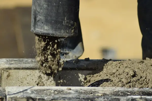 Beton wylewany z rury, rozpoczyna się proces jego wiązania. Czas, ile schnie beton, zależy od wielu czynników.