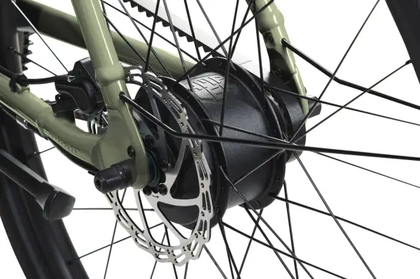 Detailaufnahme des Hinterrads eines Fahrrads mit integriertem Elektromotor und Scheibenbremse. Die Motorbremse des Elektromotors sorgt für sanftes Abbremsen.