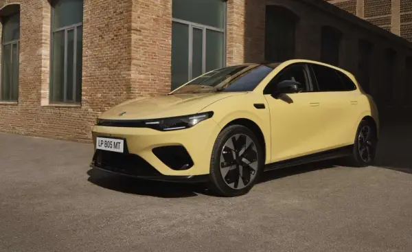 Żółty Leapmotor B05 z czarnym dachem i felgami, zaparkowany przed ceglanym budynkiem.