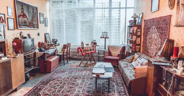 Wnętrze pełne nostalgii, jak w muzeum sentymentów. Stare meble, telewizor, dywany i bibeloty tworzą przytulną atmosferę.