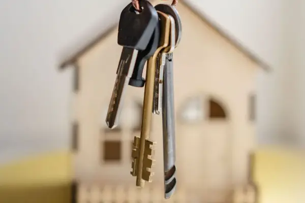 Pęk kluczy wisi na tle miniaturowego domu. Czy to symbol nowego początku, czy może niechcianego wywłaszczenia?