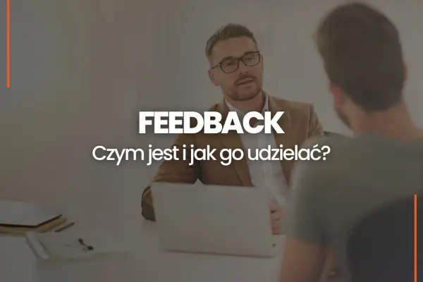 Dwóch mężczyzn przy biurku, jeden z nich udziela feedbacku. Czym jest feedback i jak go udzielać?