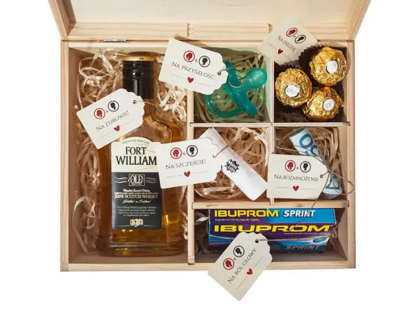 Drewniana skrzynka z zawartością: butelka whisky, smoczek, czekoladki, leki, pieniądze i losy. To idealny **niezbędnik małżeński co włożyć** na szczęście i przyszłość.
