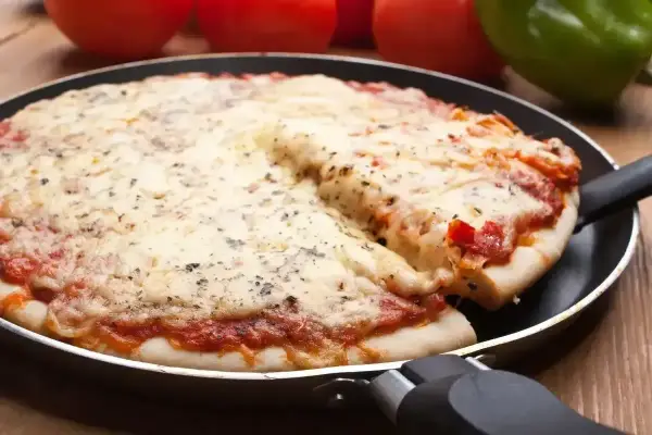 Gorąca, mrożona pizza z ciągnącym się serem, podana prosto z patelni. Idealna na szybki obiad.