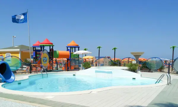 Piscina con scivolo e giochi acquatici in una giornata di sole a Cattolica, Emilia Romagna.