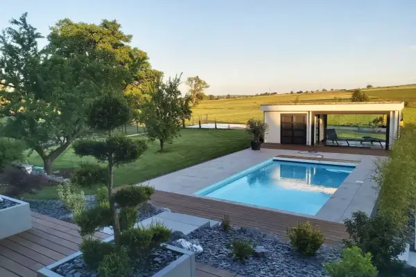 Magnifique jardin avec piscine, pelouse impeccable, arbres taillés et une petite maison moderne. Un havre de paix.