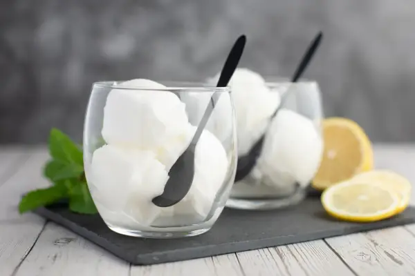 Deux verres de sorbet citron, parfaits pour un cocktail Colonel rafraîchissant, avec des quartiers de citron et de la menthe.