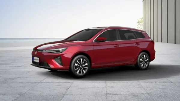 Czerwony MG5 Electric, kombi, stoi na betonowym placu z widokiem na morze.