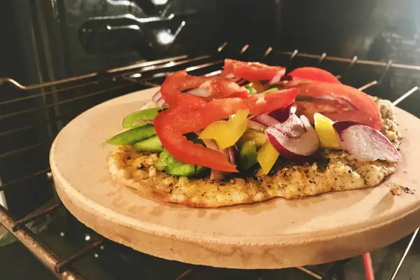 Pizza na kamieniu w piekarniku, z warzywami. Po pieczeniu, jak czyścić kamień do pizzy, by był gotowy na kolejne wypieki.