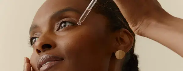 Una gota de sérum cae cerca del ojo de una mujer. Descubre la vitamina B6 para que sirve en la piel, un ingrediente clave para una piel radiante.
