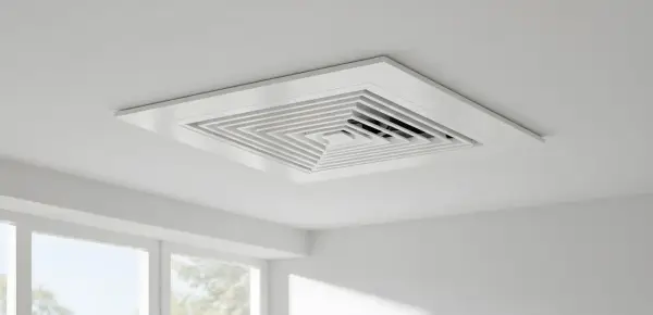 Rejilla cuadrada blanca empotrada en el techo, parte de un sistema de aire centralizado, con un diseño escalonado que dirige el flujo de aire.