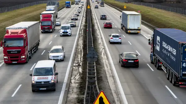 Ruch na autostradzie, gdzie wiele samochodów i ciężarówek jedzie w kierunku Wrocławia. Czy autostrada na Wrocław jest płatna?