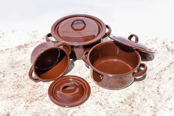 Conjunto de cazuelas de barro esmaltada en marrón. Listas para curar y preparar deliciosos guisos.