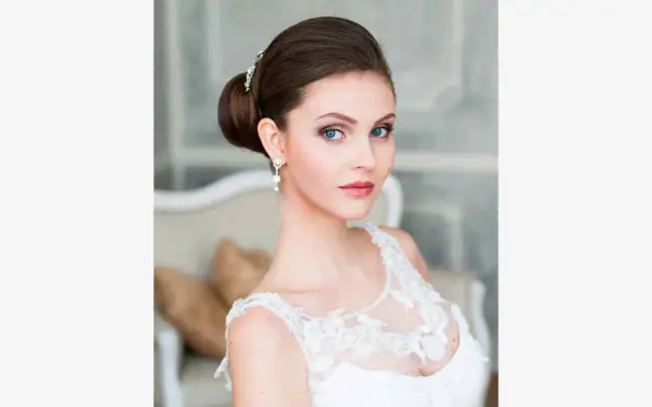 Panna młoda z eleganckim upięciem i biżuterią, w białej sukni.