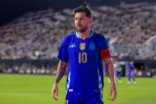 Messi w niebieskiej koszulce reprezentacji Argentyny, z numerem 10 na piersi, na tle trybun pełnych kibiców.