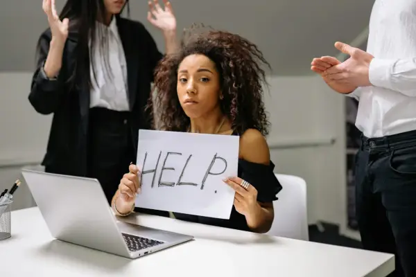 Kobieta z kartką "HELP" szuka sposobu, jak pozbyć się chwilówek. Wokół niej widać zaniepokojonych ludzi.