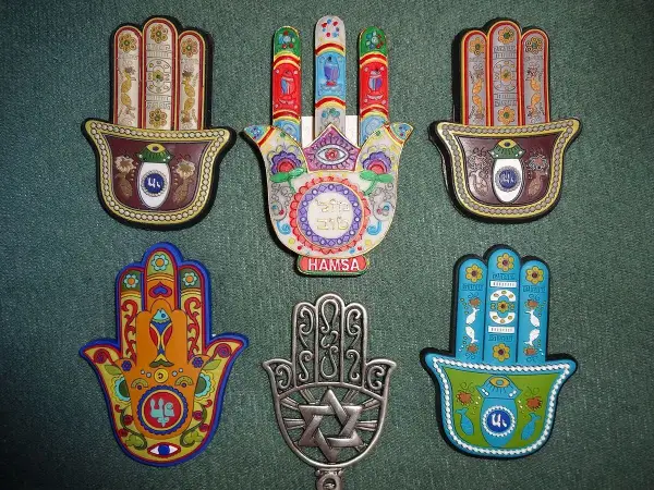 Kolekcja ozdobnych amuletów w kształcie dłoni Fatimy. Każdy **znak hamsa znaczenie** ma unikalne, symboliczne wzory i kolory, chroniące przed złym okiem.