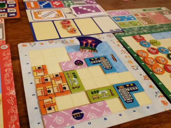 Bunte Spielbretter und Plättchen für deutsche Brettspiele. Mehrere Spieler legen ihre Züge auf dem Spielfeld ab.