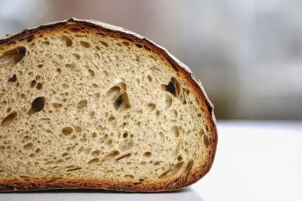 Tranche de pain artisanal à la mie aérée et à la croûte dorée. Pour savoir comment conserver le pain, il faut le garder à température ambiante.