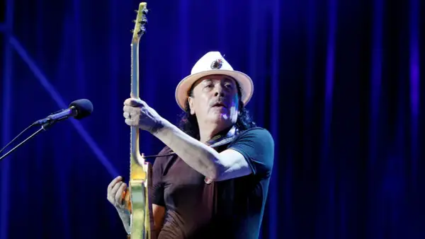 Carlos Santana z gitarą, gotowy do wykonania swoich niezapomnianych utworów.