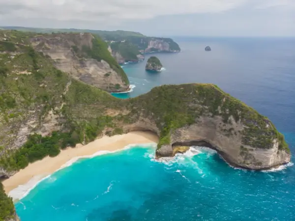 Widok z lotu ptaka na klify, piaszczystą plażę i turkusowe morze na Bali.