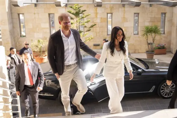 Meghan, duquesa de Sussex, sonríe mientras camina junto al príncipe Harry.